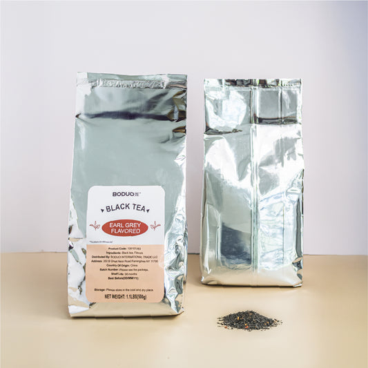 Two packages of black tea with visible branding on a light surface.