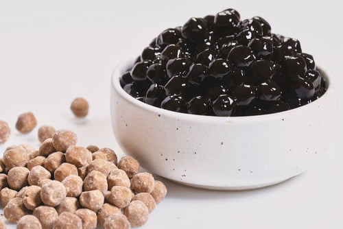 White bowl filled with tapioca pearls on a light gray background